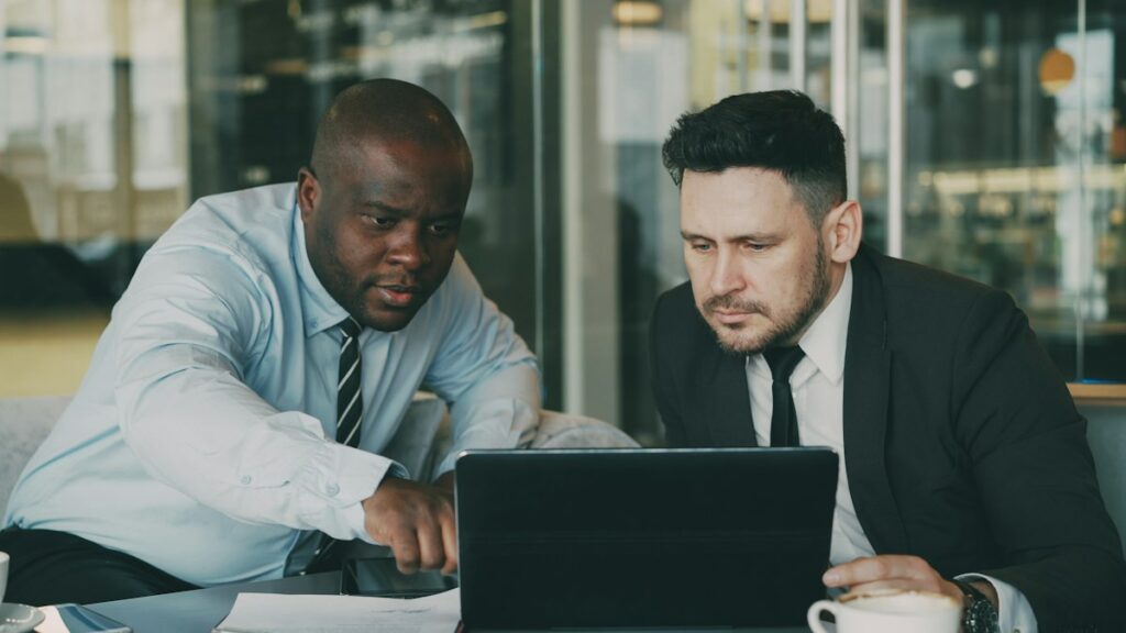 Two colleagues reviewing work on a laptop