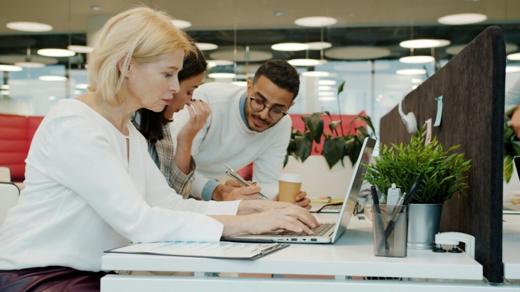 People working on laptops in a shared workspace, like remote AI training work
