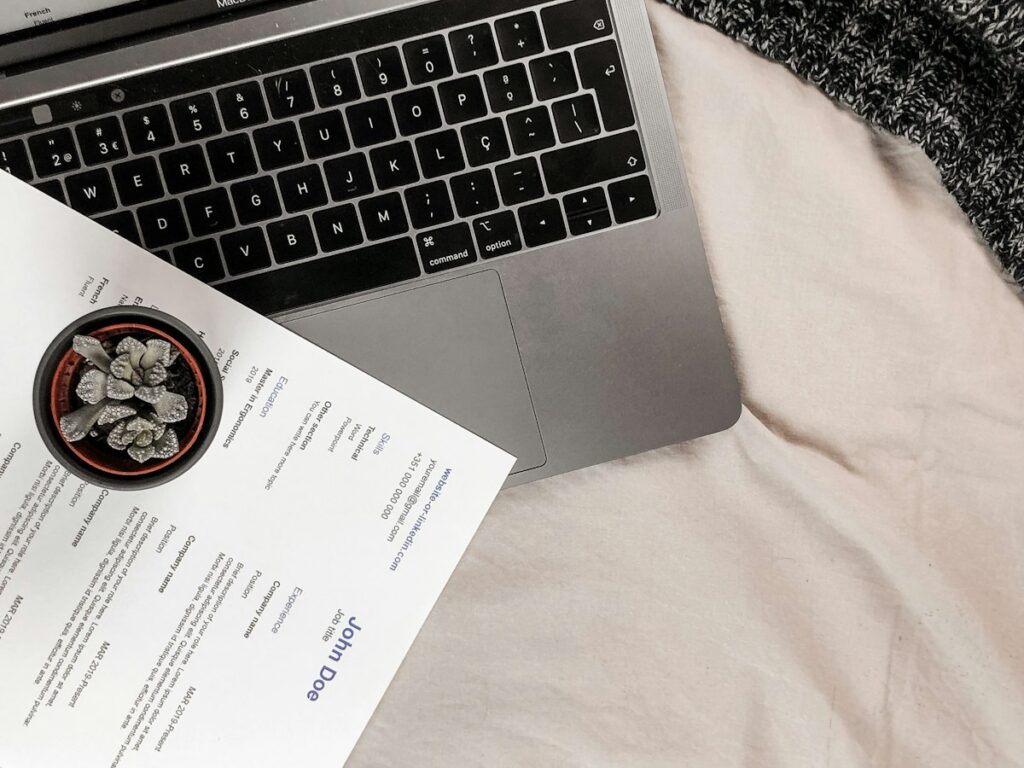 CV printout next to a laptop, ready for an ATS-friendly rewrite