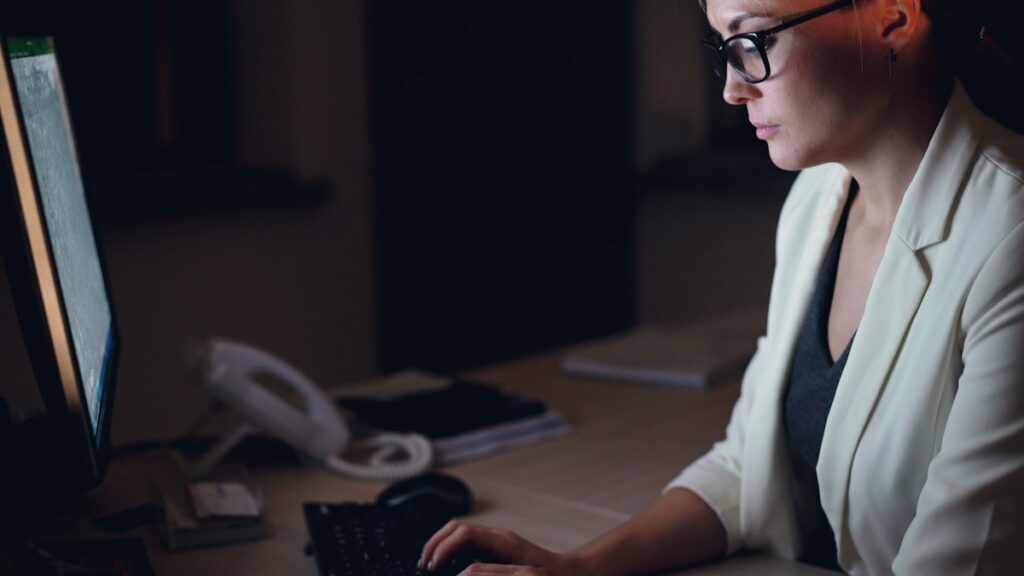 Job seeker checking a CV layout on a computer late at night