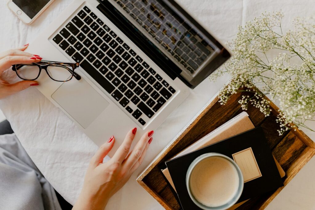 Woman designing a resume in Canva on a laptop with coffee