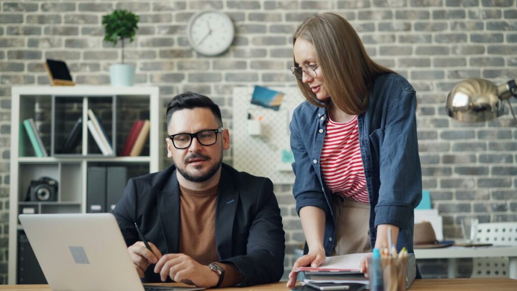 Two people comparing resume tools on a laptop